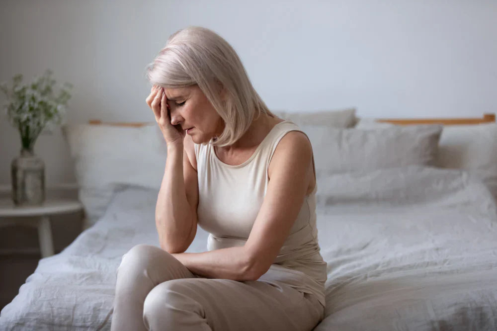 ménopause et endométriose, femme agée qui a mal et se tient la tete de douleur