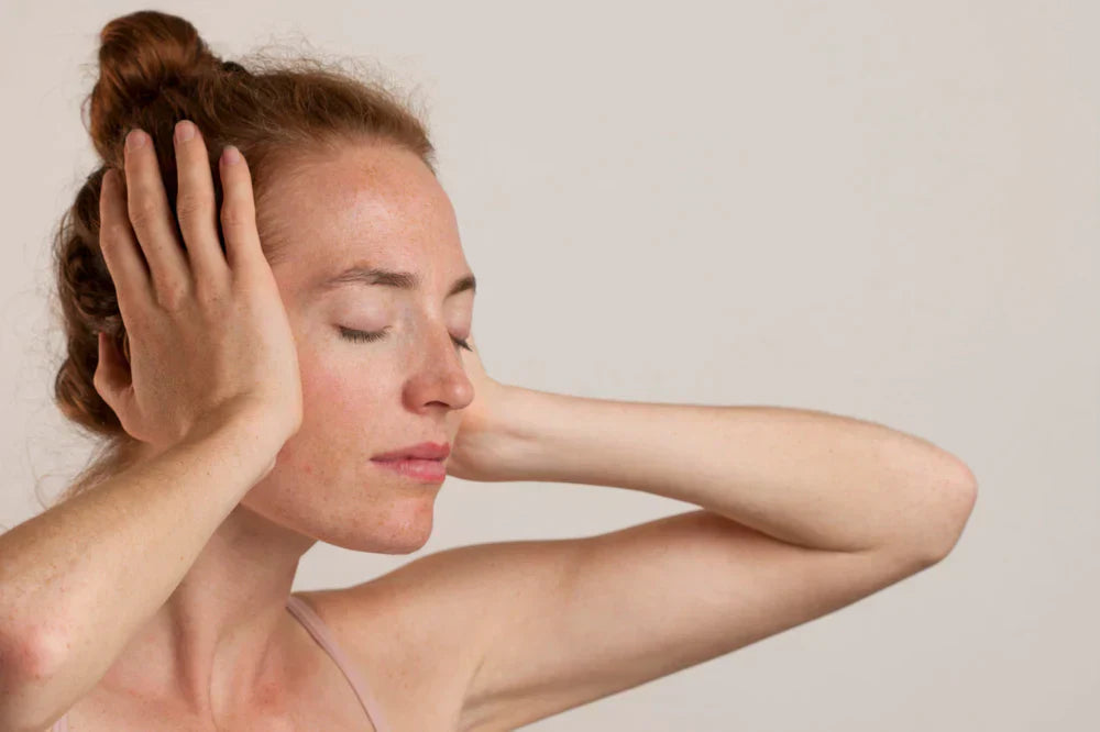femme stressée qui se tient la tête en fermant les yeux